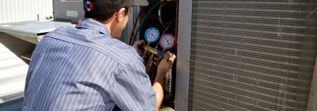HVAC technician servicing a condenser unit in Beaufort