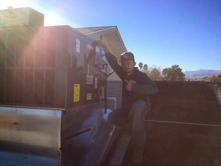 HVAC technician performing Heat Pump Repair on a rooftop unit in Beaufort